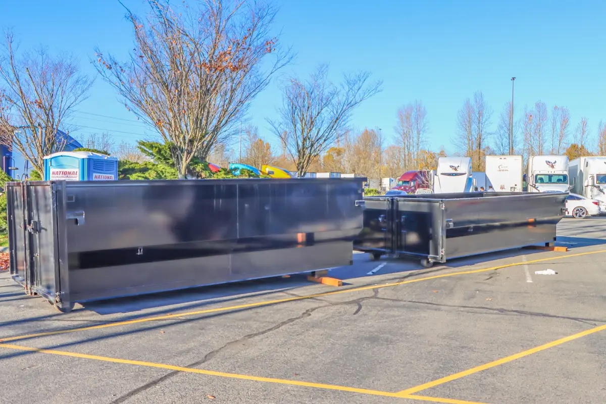 Professional dumpster rental service with roll-off container on residential driveway in De Witt